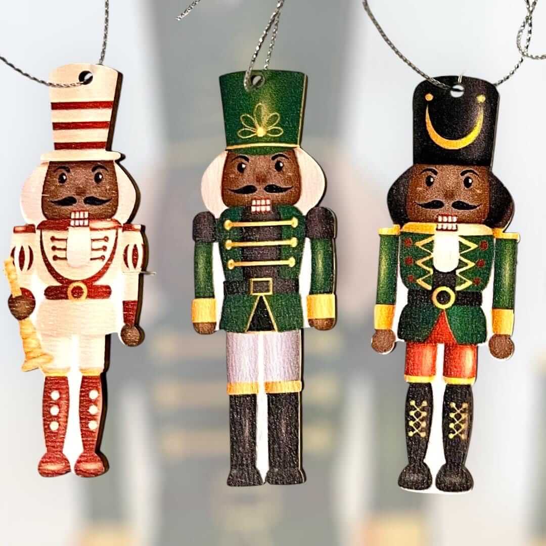 Vintage-inspired Nutcracker ornaments set, featuring King and Soldier figures in diverse outfits, hanging on a Christmas tree.